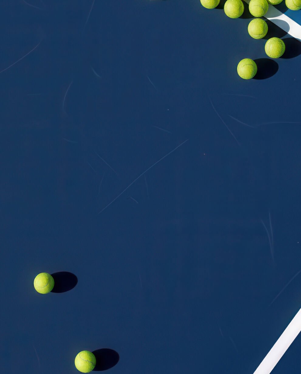 Tennis balls laying on a tennis court.