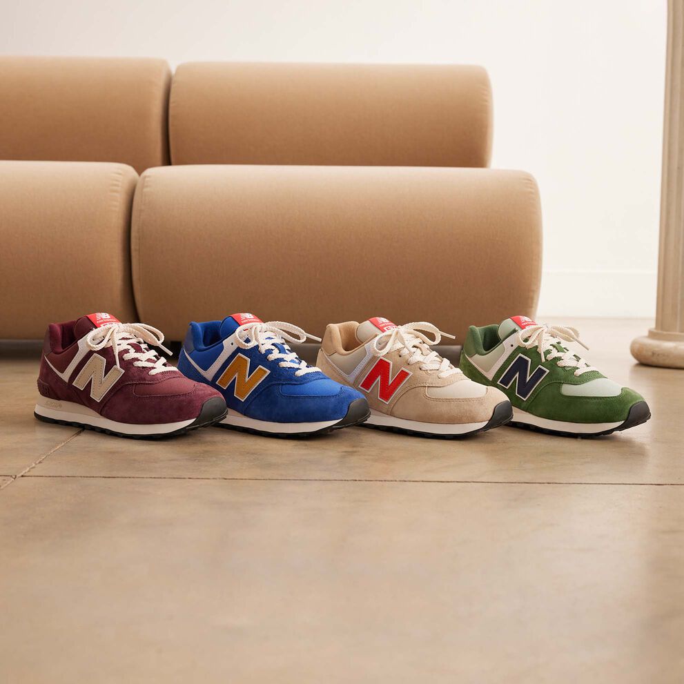 Four New Balance 574 standing on a row on a light brown floor
