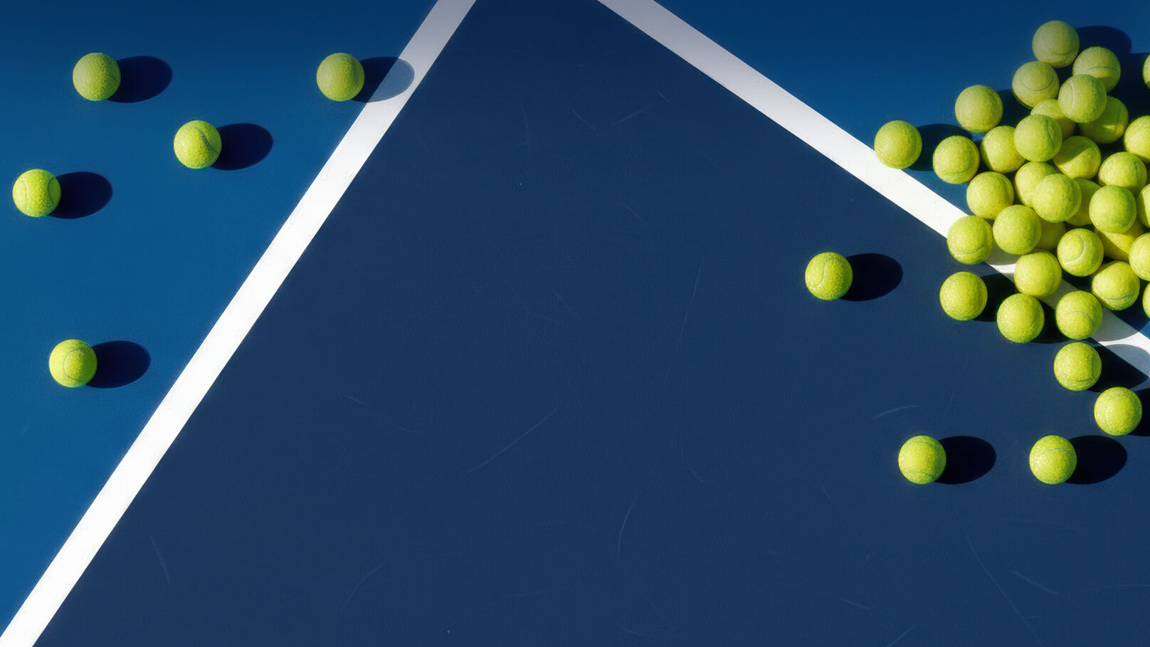 Tennis balls laying on a tennis court.