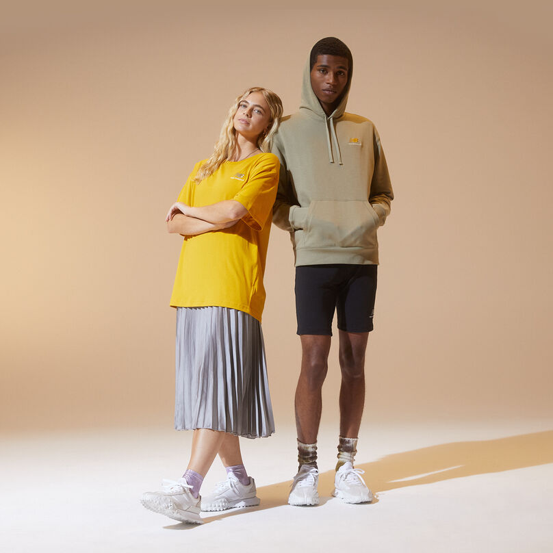 Two people wearing multi-colored NB athleticwear against a light brown background