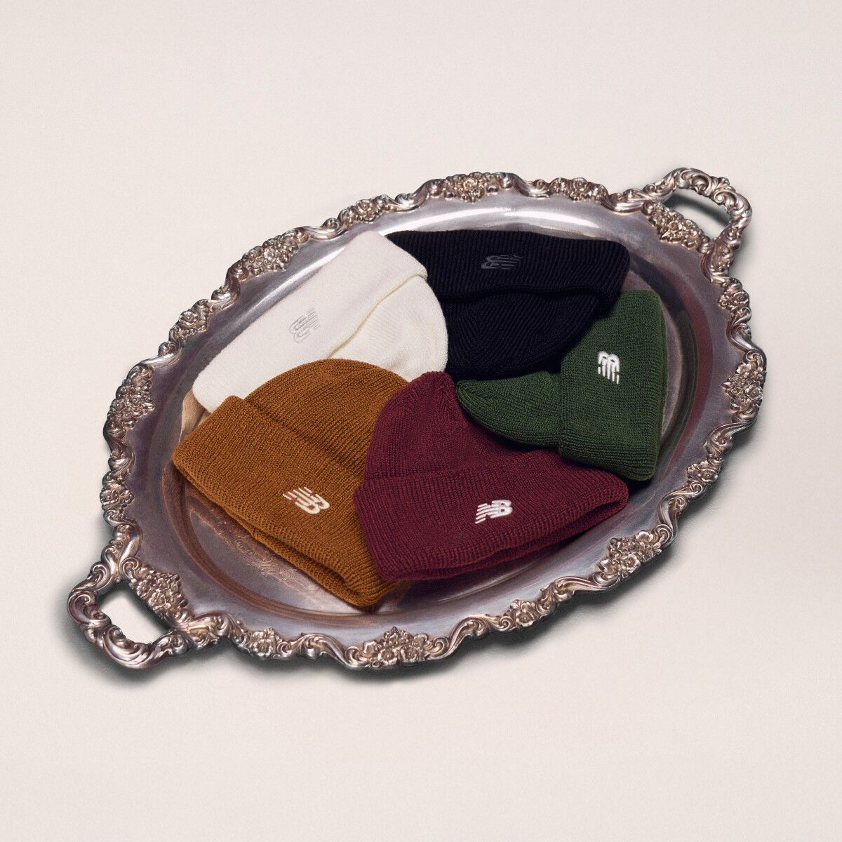 Silver platter holding five different color beanies.