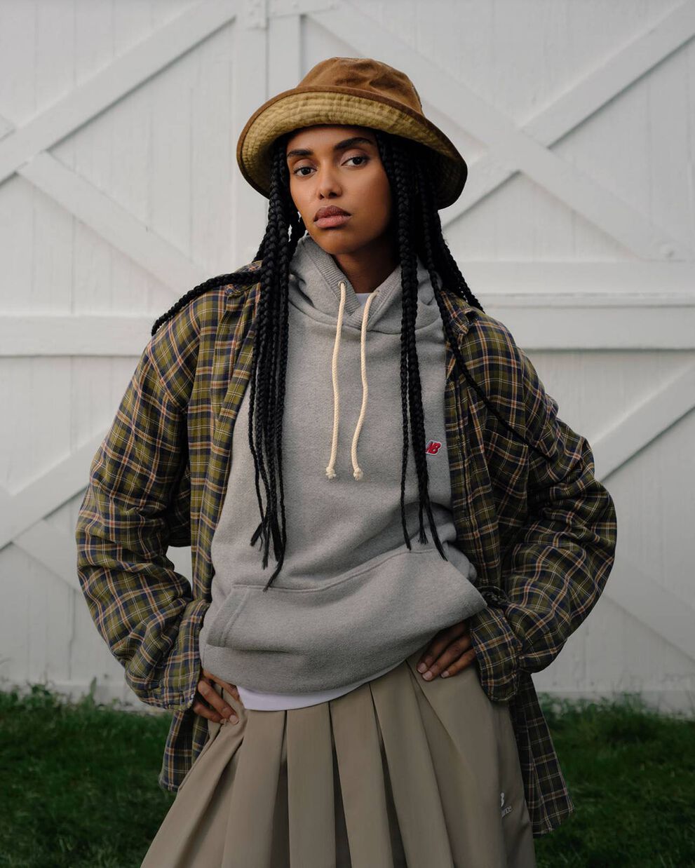 A woman standing against a barn backdrop. 